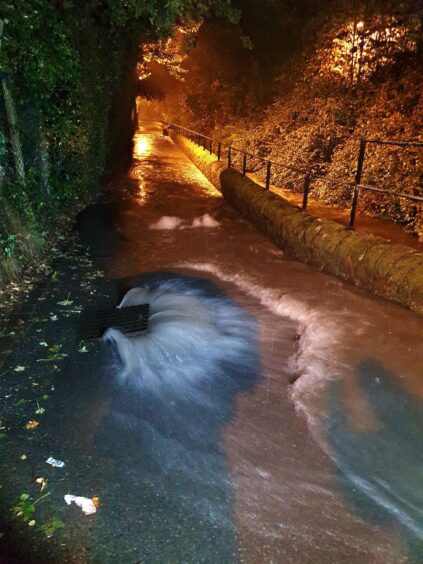 Overflowing drain in Craigie area of Perth during flooding.