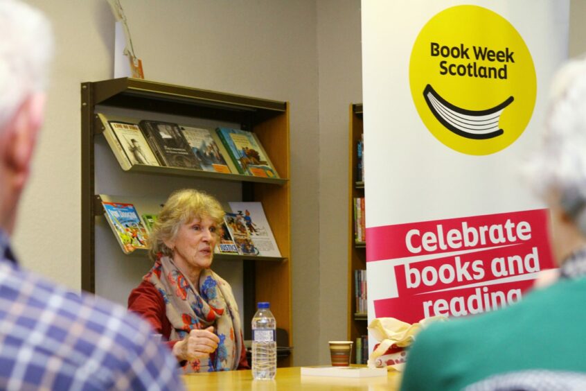 Jess Smith talking at library event in front of Book Week Scotland banner