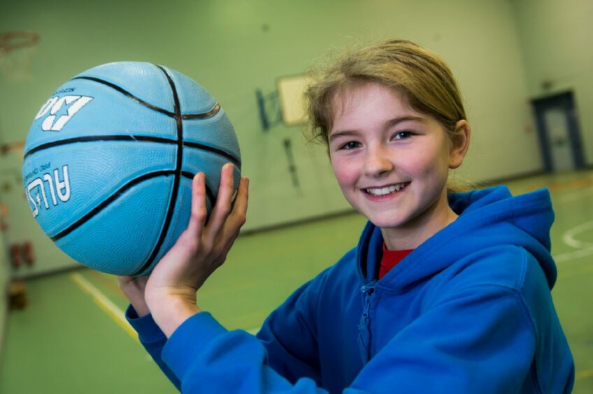 Ella Doherty holding a basketball when she was younger