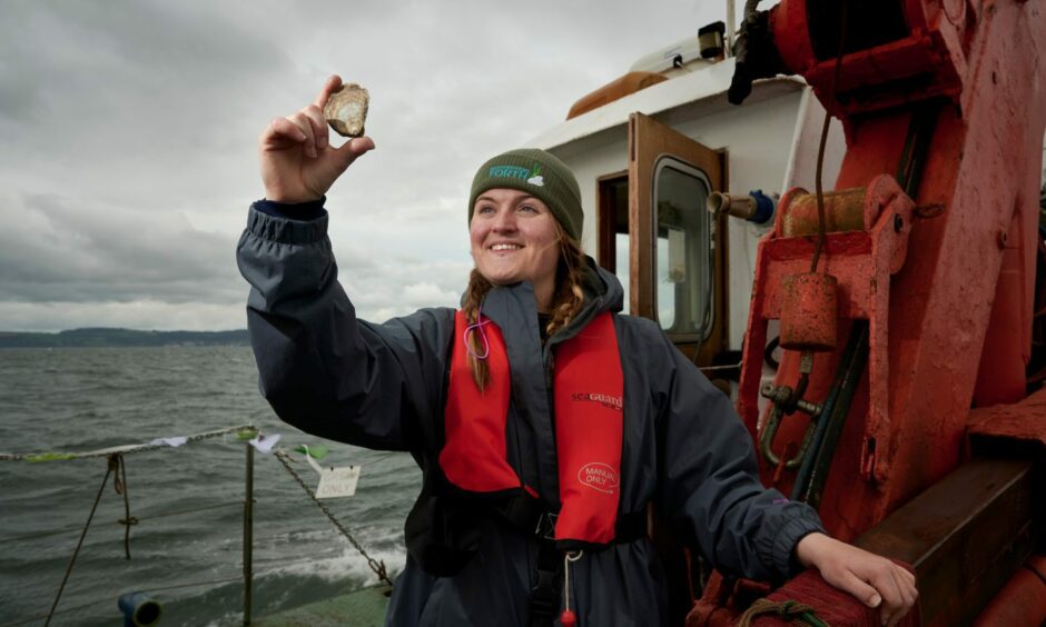 Emmy Cooper from Heriot Watt University about to return an oyster to the Firth of Forth