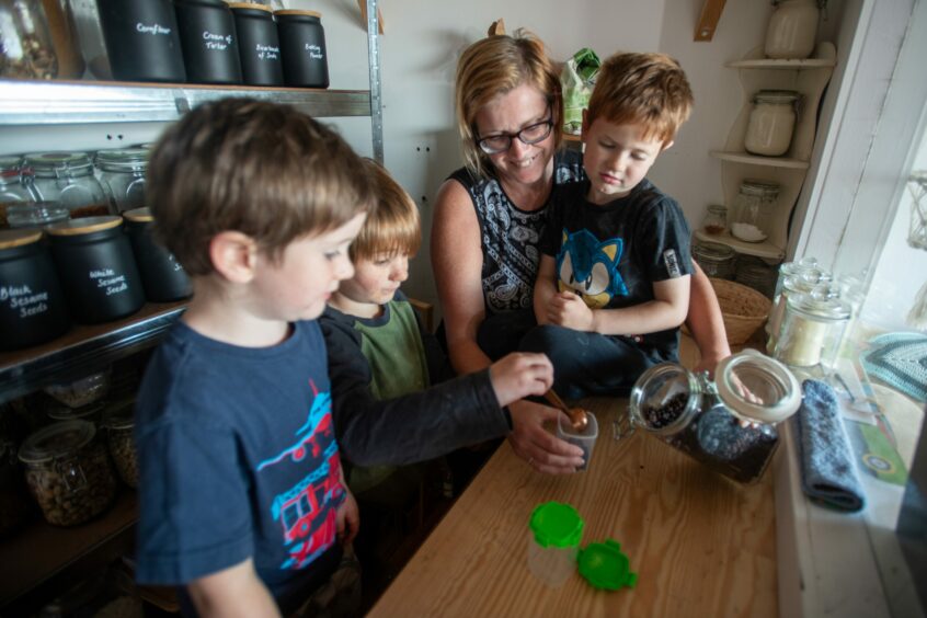 Kinghorn Mum Louise and sons Cillian, Isaac and Quinn weighing out zero waste products from a jar. 