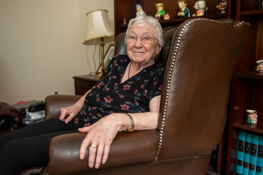 Marjorie Bridgwood smiling from her chair.