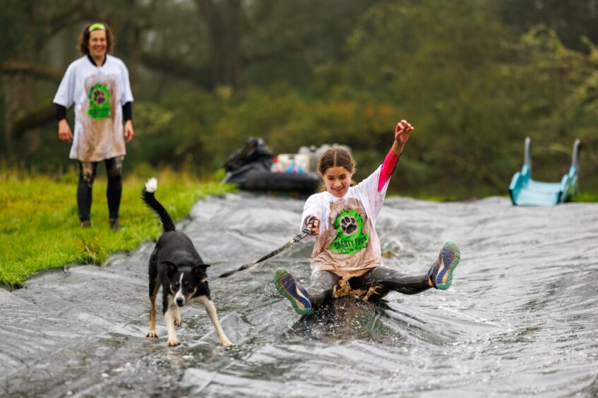 Helen Cluett with daughter Allysa, 12, and Jill the collie dog on the water slide at Auchingarruch