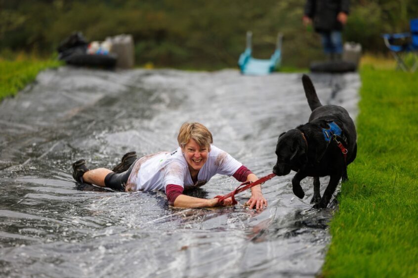 Kerry Donaldson with her labrador dog Blue coming down the water slide. 