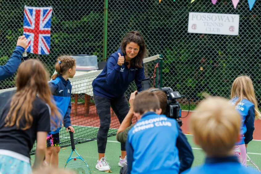 Alessia Palmieri giving thumbs up sign to young tennis players at Fossoway tennis club.