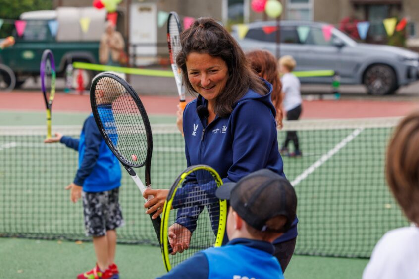 Alessia Palmieri smiling as she speaks to a small boy holding a tennis racquet at Fossoway.