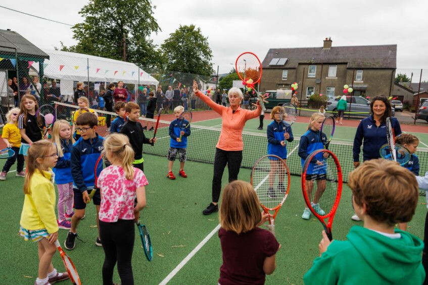 Judy Murray and Alessia Palmieri leading tennis coaching session with large group of spectators watching from side.
