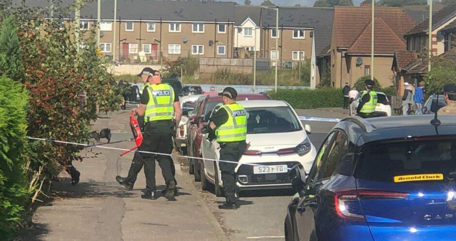 Police entering a property on Ambleside Avenue in Kirkton, Dundee.