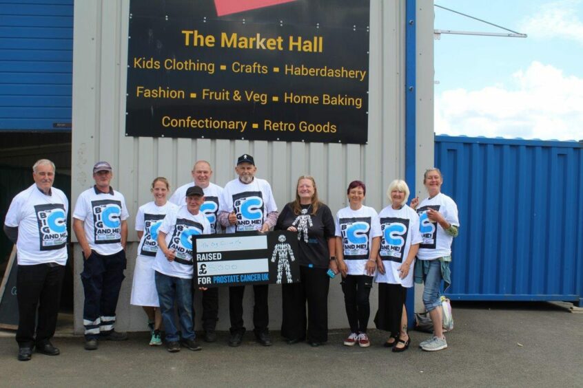 Keith Payne presenting £5,000 to a group in Prostate Cancer UK t shirts.