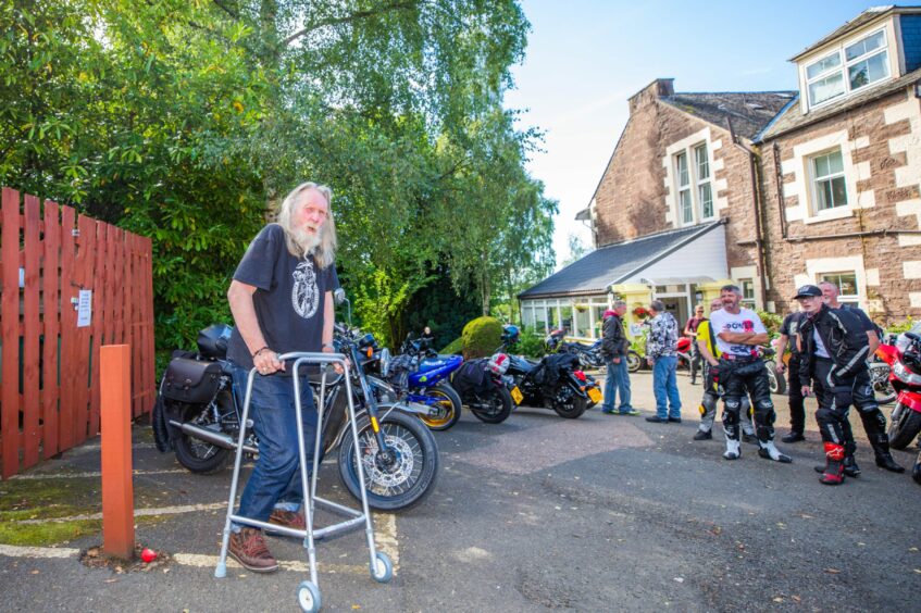 John Neilson, standing behind walking frame, speaking to crowds of bikers at the Birches care home in Crieff.