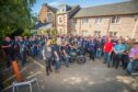 Large group of bikers in the grounds of the Birches care home, Crieff, with Helen Maclellan and John Neilson in front.