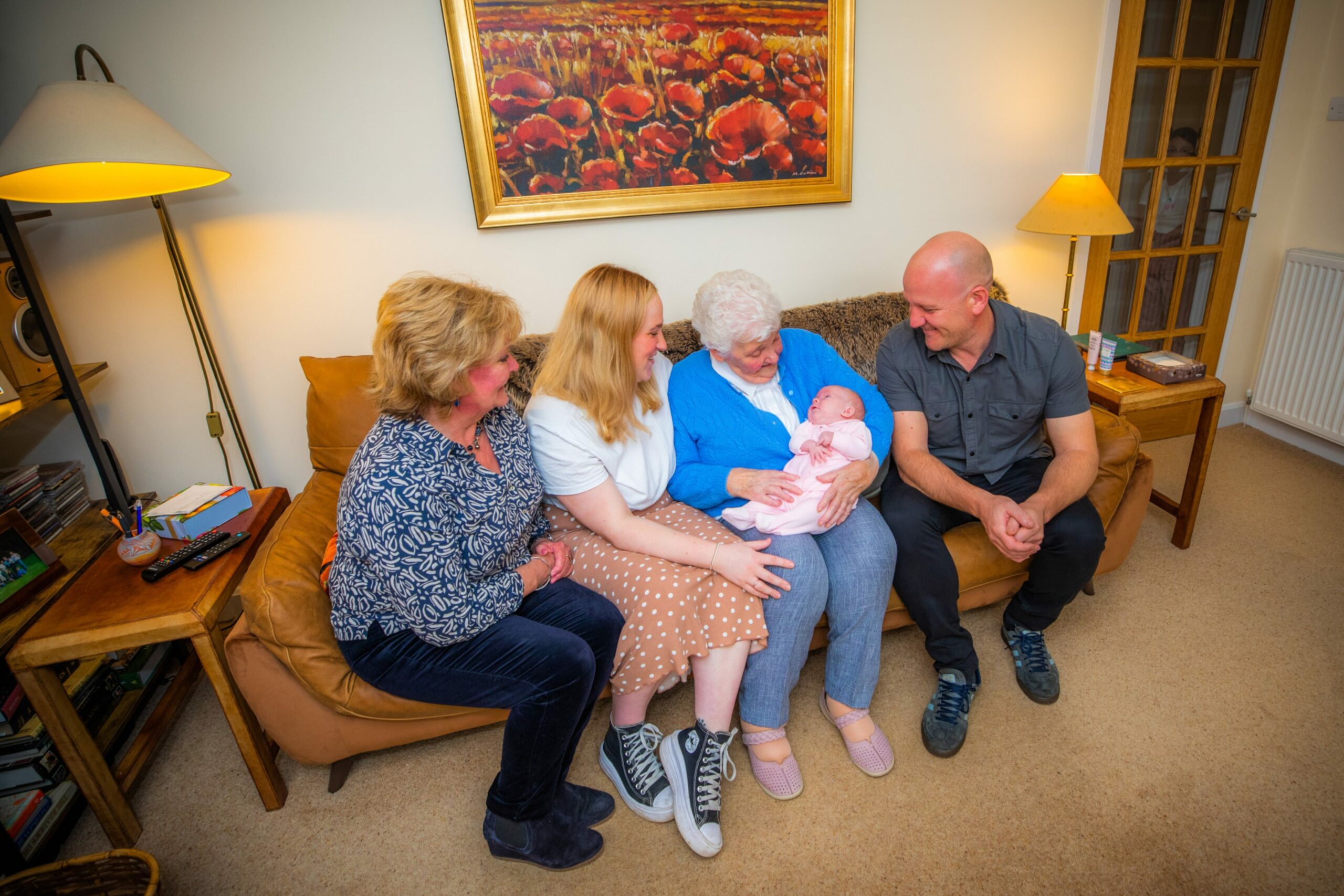 The five generation perthshire family looking at Louella on a couch 