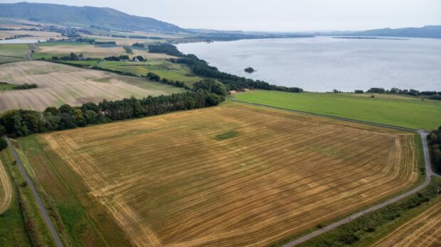 aerial view of Burleigh Golf site, currently a stubble field, with Loch Leven in background.