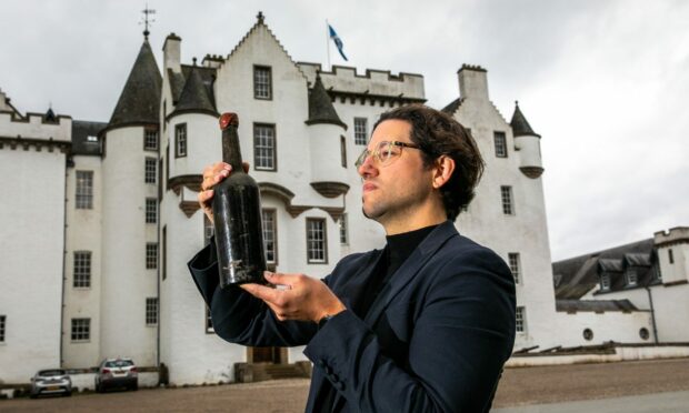 Joe Wilson, head curator and spirits specialist at Whisky Auctioneer, inspects the whisky found at Blair Castle