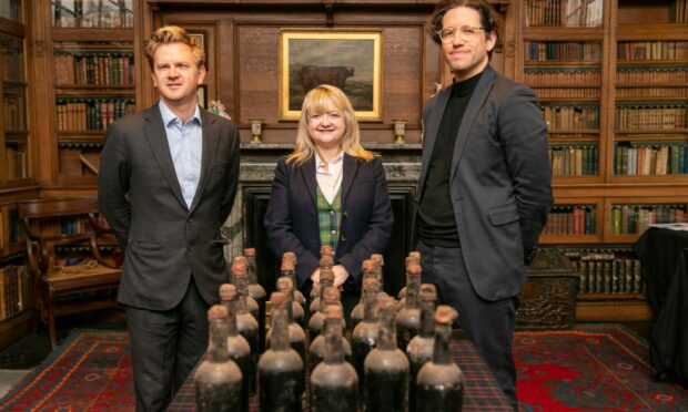 Bertie, Keren and Joe standing behind a table of whisky in Blair Castle