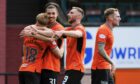 Kai Fotheringham is mobbed by Dundee United players after scoring.