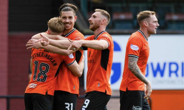 Kai Fotheringham is mobbed by Dundee United players after scoring.