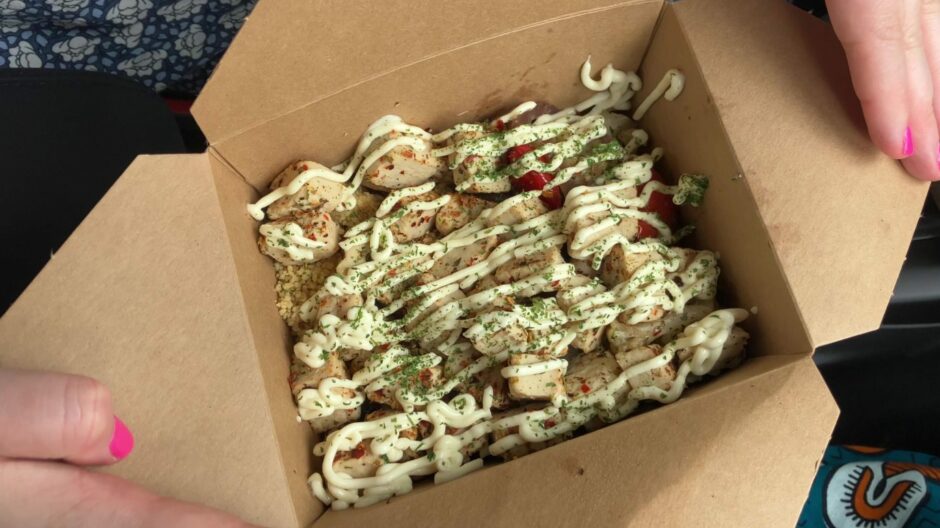 A takeout box of vegan chicken, couscous, veg and garlic aioli