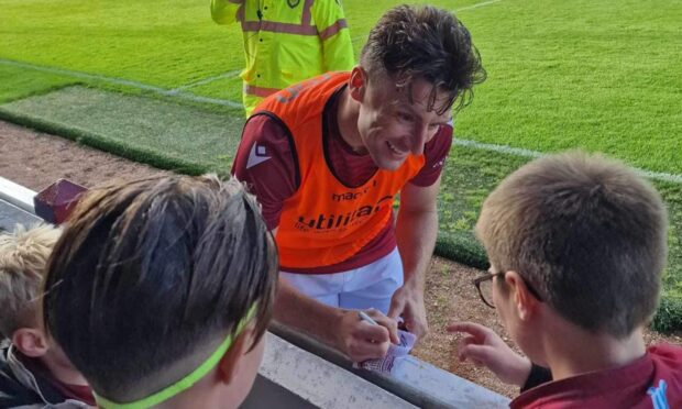 Arbroath midfielder Michael McKenna signs autographs at the end of his side's win over Airdrieonians.