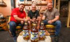 Angus Alchemy co-owners Campbell Archibald, Phil Paton and Martin Brown raise a glass of Mistaken Identity Moonshine to Doddie.   Image: Mhairi Edwards/DC Thomson