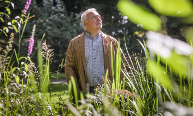 Kevin Frediani, Curator of Dundee Botanic Garden walks near the pond where rewilding is taking place. Image: Mhairi Edwards/DC Thomson