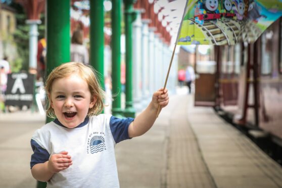 Three-year-old Forrest Barrett cheers Thomas from the Caley platform. Image: Mhairi Edwards/DC Thomson