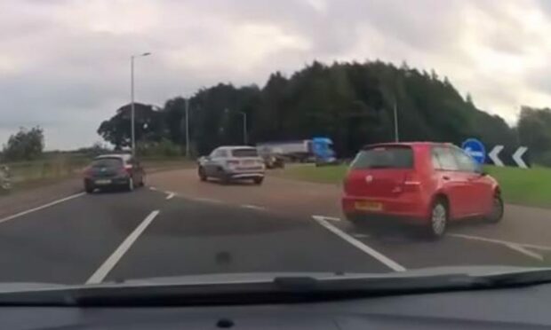 A red car turning the wrong way onto the Forgan Roundabout in Fife