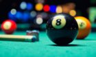 Snooker balls and cue on a snooker table.