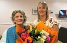 Babs Somerville accepting a bouquet from Balhousie Rumbling Bridge care home manager Morag Shea