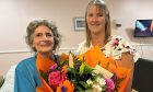Babs Somerville accepting a bouquet from Balhousie Rumbling Bridge care home manager Morag Shea