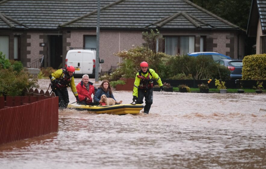 Brechin residents pulled to safety in dinghy boat as streets are flooded from Storm Babet. 