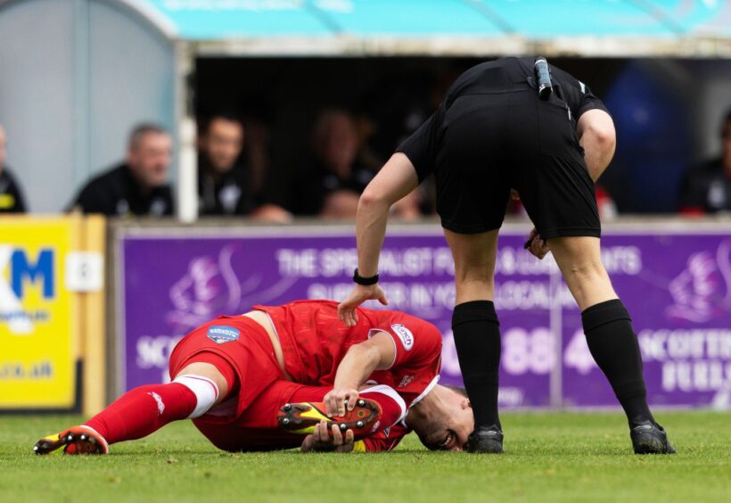 Dunfermline's Kyle Benedictus, lying on the field and holding his foot, picked up an injury in September. Image: SNS.
