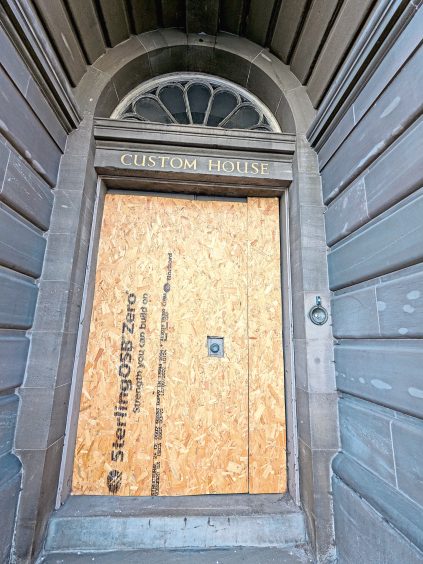 A boarded up doorway to abandoned Custom House in Dundee. 