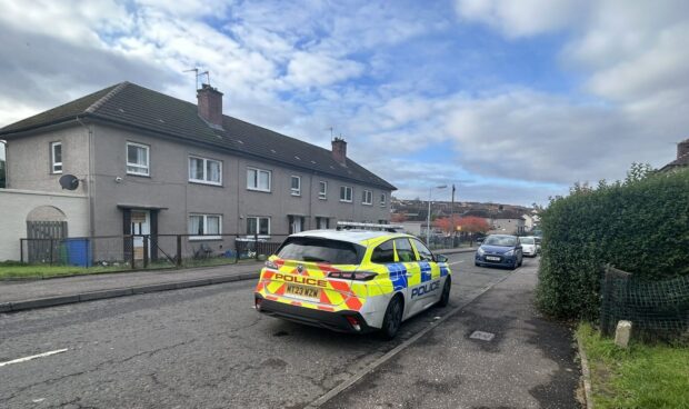 A single police car outside the house in Ballingry where the teenager fell ill.