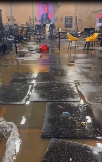 Interior of Bell's Sports Centre gym showing dirty water all over floor and gym equipment under water