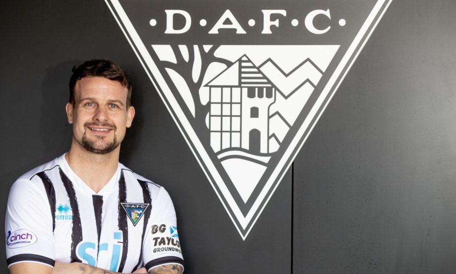 Dunfermline Athletic captain Kyle Benedictus, pictured standing before the club crest, was 'delighted' to extend his stay. Image: Craig Brown/DAFC.