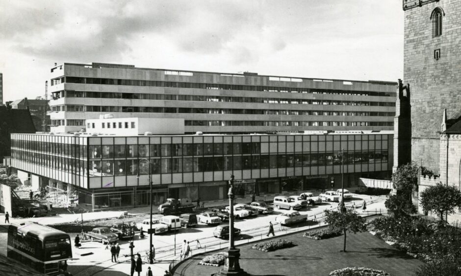 People walk by and cars are parked outside as the first phase of the Overgate opened in 1963. 