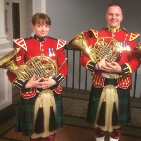 Joanne and Jon Lumb in band uniforms holding French horns