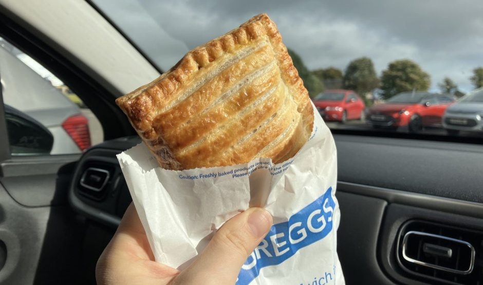 A sausage, bean and cheese melt from Greggs sticking up from its wrapper