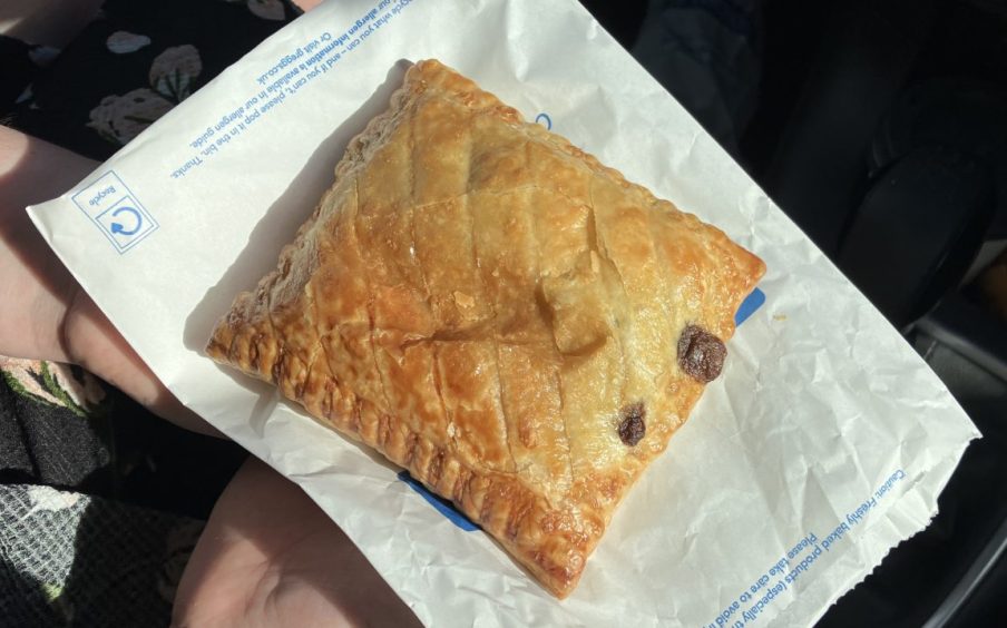 A Greggs steak bake resting on top of its paper bag.