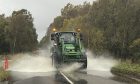 A tractor flies through flooding on the Forestmuir stretch between Forfar and Kirriemuir.