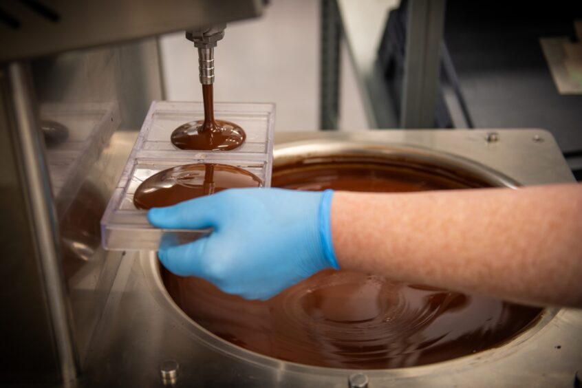Two chocolate moulds being filled with tempered Ocelot chocolate.