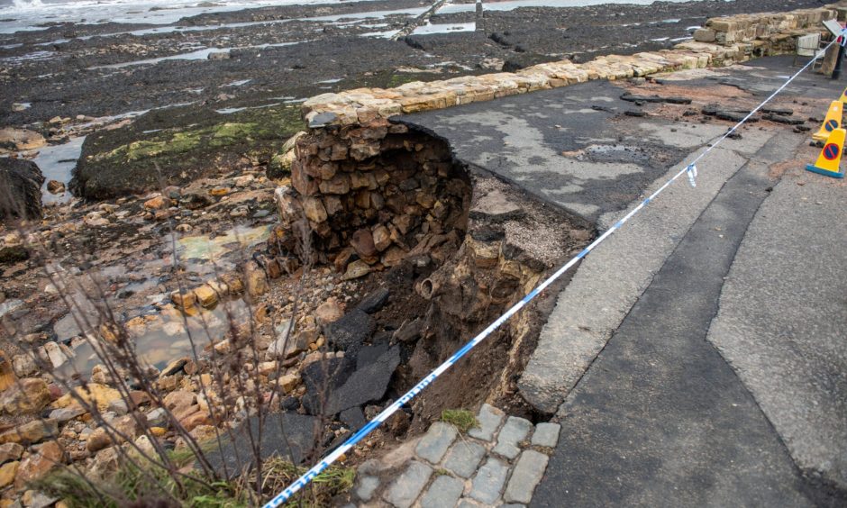 Walkers face a sheer drop at St Andrews Harbour due to storm damage.