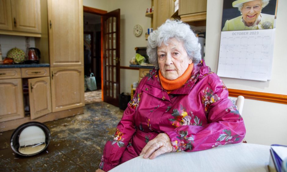 June Reid, from heron Rise in Dundee, Sitting in flooded home