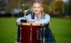 Flora McNab, with tenor drum and world championship trophy.
