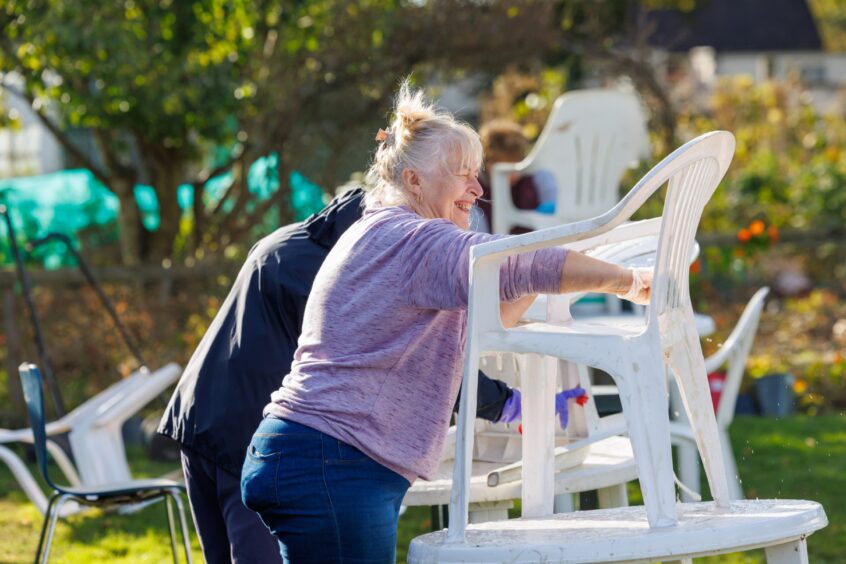 Women wiping down chairs at the Moncreiffe island allotments