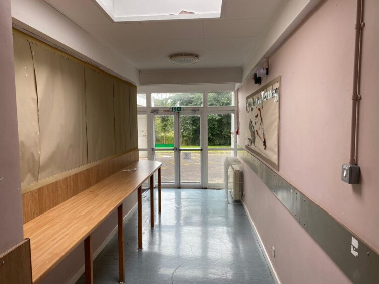 Forteviot school corridor with pink painted walls and old notice boards.