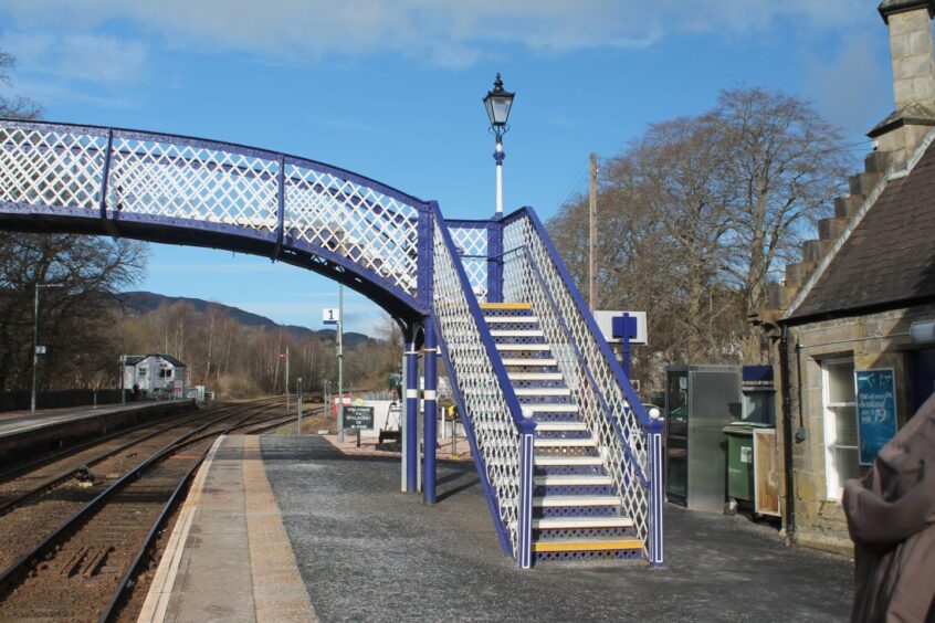 Pitlochry Station's blue and white iron pedestrian footbridge.
