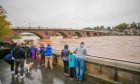 Group of onlookers watch as the River Tay rises in Perth during flooding in October 2023