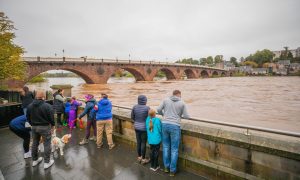 Group of onlookers watch as the River Tay rises in Perth during flooding in October 2023